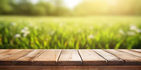 Foto op Canvas Wooden table with green grass background and sunlight. © Sona