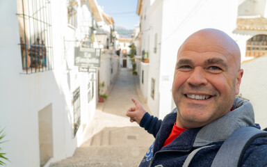 Happy tourist takes a selfie sign thums up, in Altea, Alicante (Spain).