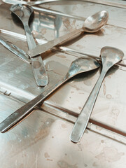 Close up view of stainless steel teaspoons drying on a draining board