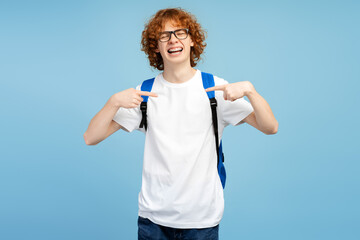 Smiling teenage boy wearing casual white t shirt pointing himself standing with closed eyes