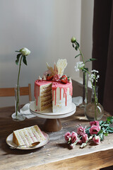 Birthday or wedding cake with flowers on wooden table