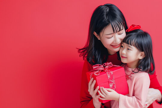 Smiling Mother Hugging Daughter with Present on Red