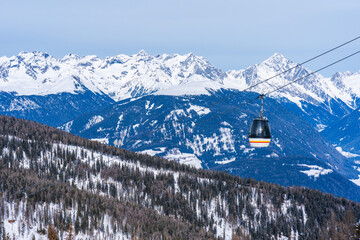 Cable car gondola against snow covered Dolomites inn Kronplatz in the winter, South Tyrol, Italy