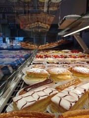 bright french pastries in a baker window, with millefeuille, flan and fruits tarts