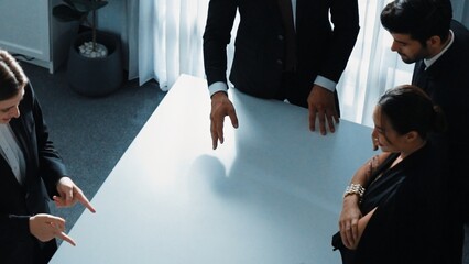 Top view of project manager looking at meeting table surrounded by diverse business people brainstorm and planning strategy. Group of smart people discussing and solve business problems. Directorate.