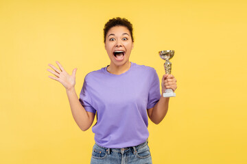 Overjoyed smiling African American woman, competition winner holding trophy cup looking at camera