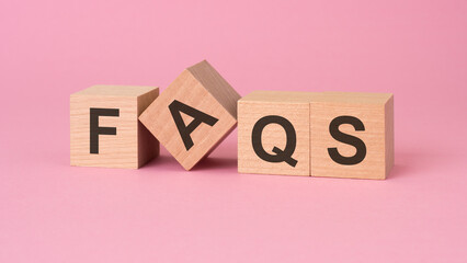 the arrangement of wooden cubes spelling 'FAQS' implies providing clarity, assistance, and guidance...