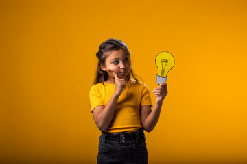 Thoughtful child girl holding paper bulb. Success, motivation, winner, genius, idea concept