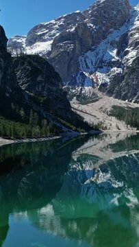 Aerial view of mountain Lago di Braies - Lake Braies in Dolomite Alps, South Tyrol, Italy. Vertical video