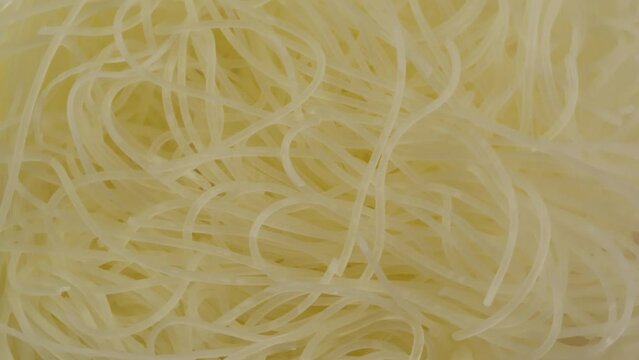 Close-up of Funchoza instant noodles texture. Asian fast food with meat and spices. Instant noodles, or instant ramen, is a type of food consisting of noodles sold in a precooked and dried block with