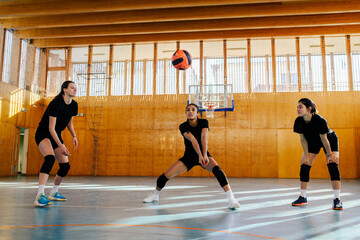 An interracial volleyball team in action practicing volleyball on court.