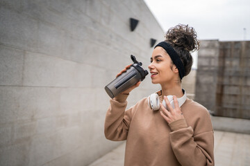 One young woman caucasian female hold supplement shaker outdoor in day