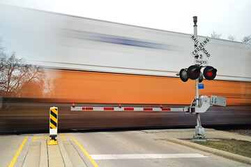 Blurred freight train in motion at crossing gate