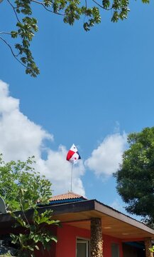 Bandera de Panam&aacute; ondeando en un d&iacute;a soleado de verano en una casa tradicional paname&ntilde;a.