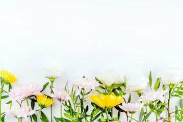On a white background with a place for writing text, yellow, pink and white flowers.