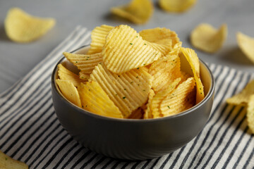 Organic Crinkle Sour Cream and Onion Potato Chips in a Bowl, low angle view. Close-up.