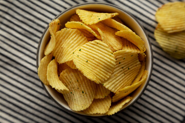 Organic Crinkle Sour Cream and Onion Potato Chips in a Bowl, top view. Flat lay, overhead, from...