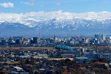 呉羽山から富山市市街地の向こうに北アルプスの雪を冠った山々