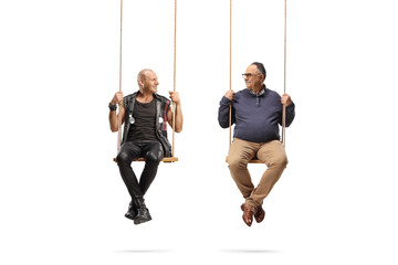 Punk and mature man sitting on swings and looking at each other