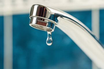 A drop of water drips from a leaky faucet
