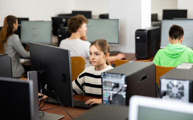 Obraz premium Schoolgirl using computer during computer sciene lesson in school.