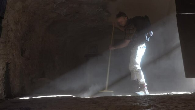 Roccamorice, Italy A man sweeps a dirt floor Eremo di San Bartolomeo sanctuary, an old monastery.