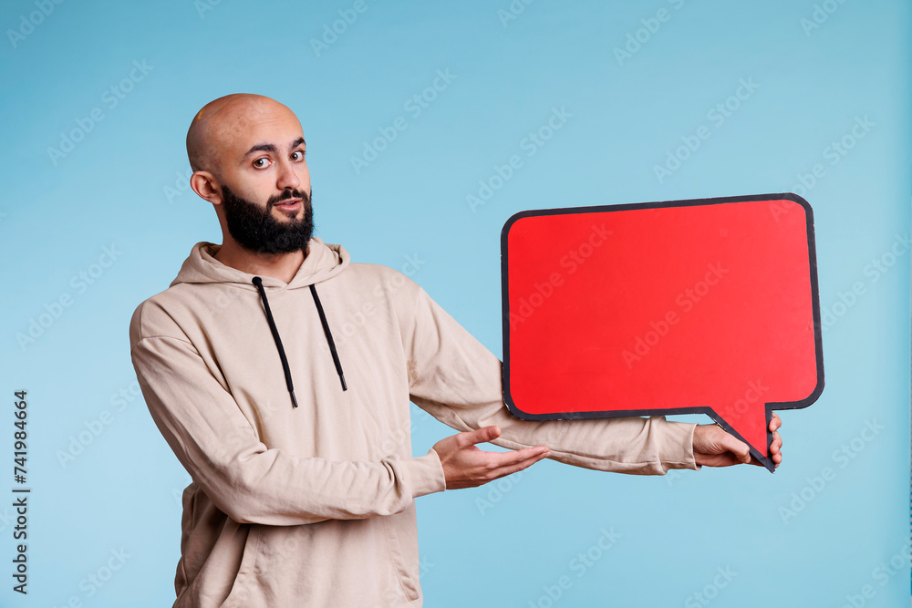 Poster arab man presenting product with empty speech bubble for promotional message mock up. young arabian 