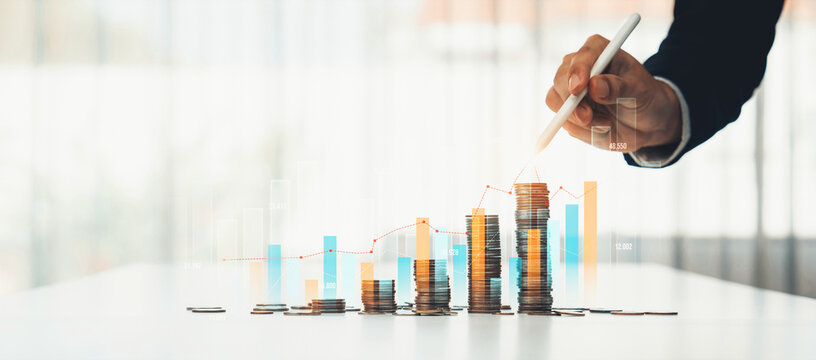 Coin stack with digital graphic indicator symbolizing business investment and economic growth. Businessman doing financial planning to achieve financial goal and contribute to profit. Shrewd