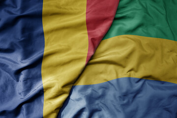 big waving national colorful flag of gabon and national flag of romania .