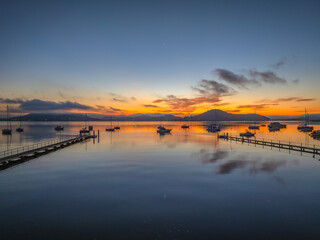 Sunrise over the calm water with boats and reflections