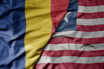 big waving national colorful flag of liberia and national flag of romania .