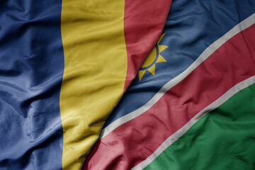 big waving national colorful flag of namibia and national flag of romania .