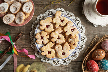 Obrazy na Plexi  Homemade Linzer cookies in the shape of animals on a plate, with Easter eggs decorated with wax