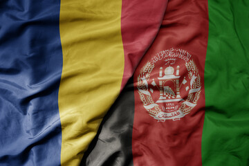 big waving national colorful flag of afghanistan and national flag of romania .
