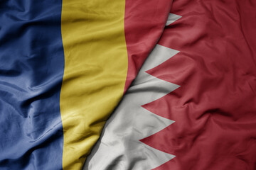 big waving national colorful flag of bahrain and national flag of romania .