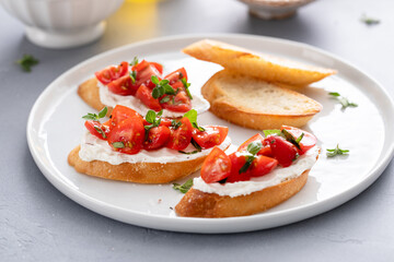 Making tomato basil crostini or bruschetta with toasted baguette
