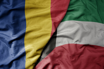 big waving national colorful flag of kuwait and national flag of romania .