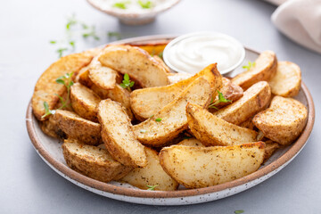 Roasted potatoes with parmesan and herbs served with creamy sauce for dipping