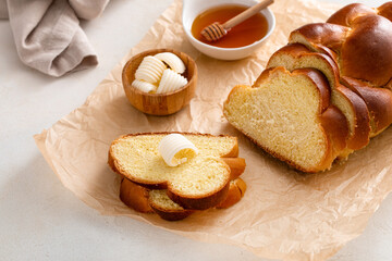 Homemade challah with honey sliced on the table