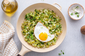 Sauteed green cabbage or lettuce with fried egg, healthy breakfast idea