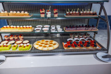 Close up view of a shelf with colorful pastries and desserts. Curacao.