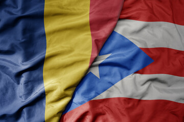 big waving national colorful flag of puerto rico and national flag of romania .