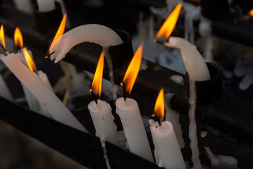 Several lit candles burning during the day. Concept of religiosity.