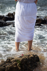 Lower part of the legs of unidentified people on the beach.