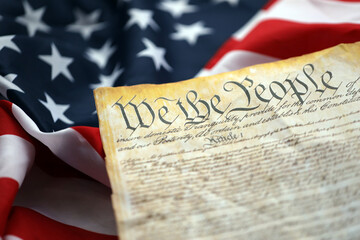 Preamble to the Constitution of the United States and American Flag. Old yellow paper with We The People text