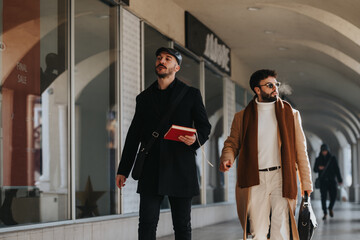 Two stylish, professional businessmen work-related discussion while walking outdoors in a contemporary urban environment.