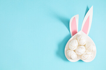 Easter holiday composition. Easter decorations, funny bunny ears , colorful eggs on isolated pastel blue background. Easter concept. Flat lay, top view, copy space 