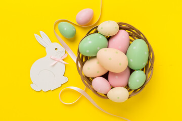 Easter bunny with eggs on color background, top view