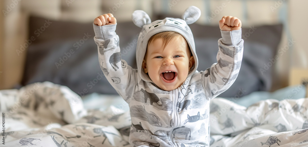 Wall mural baby rejoices in bed in the morning