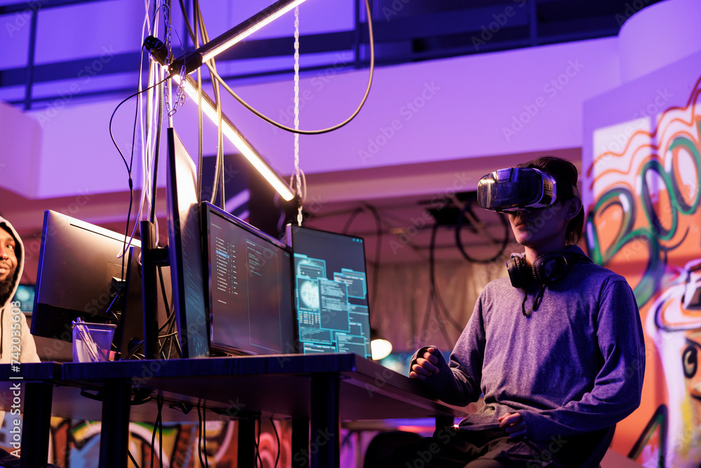 Poster hacker wearing vr glasses, immersed in simulation while doing illegal activity. young criminal using